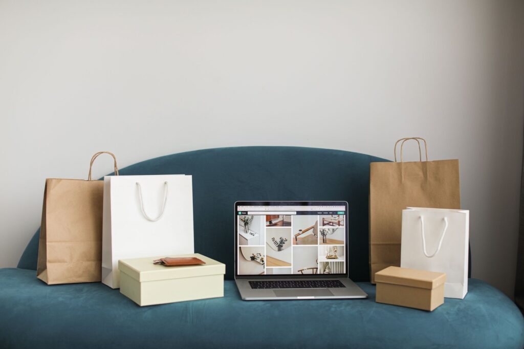 Comprar da China online — laptop com site de compras cercado por sacolas e caixas